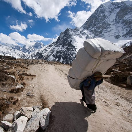 Nepal guy carrying a huge bag on his back