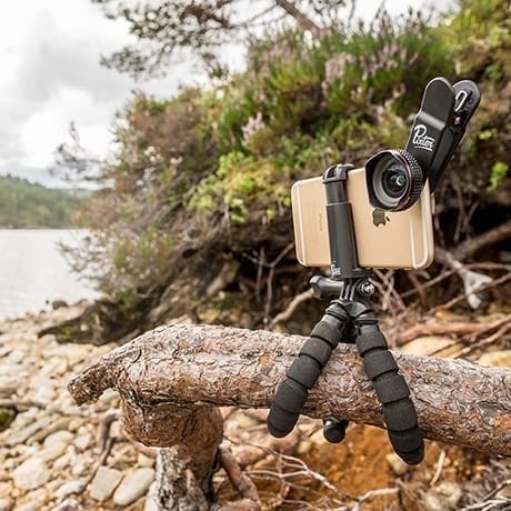 Smartphone with a lens put on a tripod fixed on a tree branch