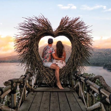 A couple sitting in a giant heart made of straw