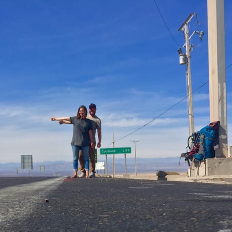 A travelling couple hitchhike