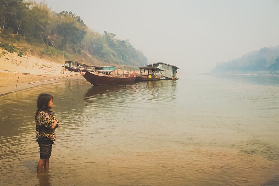 Slow Boat traditionnel sur le Mékong et petite fille les pieds dans l'eau - Laos